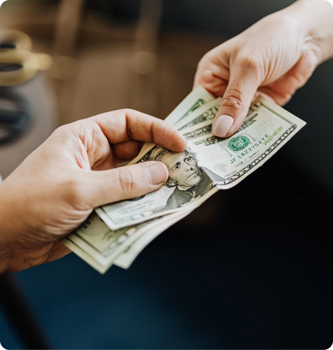 A person handing over cash for gold at a pawn shop in Brockton MA
