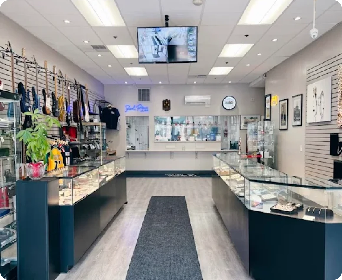 A modern, well-lit, and clean pawn shop in Brockton MA, with multiple display cases and a TV on the wall, offering cash for
