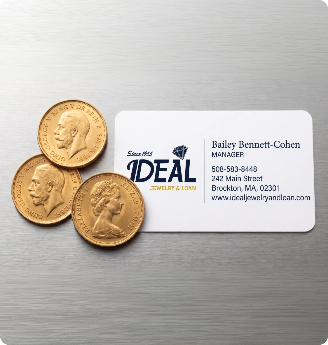 Three gold coins and a business card on a wooden table in Brockton MA, with a pawn shop and cash for gold and loans