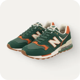 Brockton MA A pair of New Balance 574 sneakers in a dark green and orange color scheme