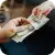 A person holding a stack of cash in front of a pawn shop in Brockton MA